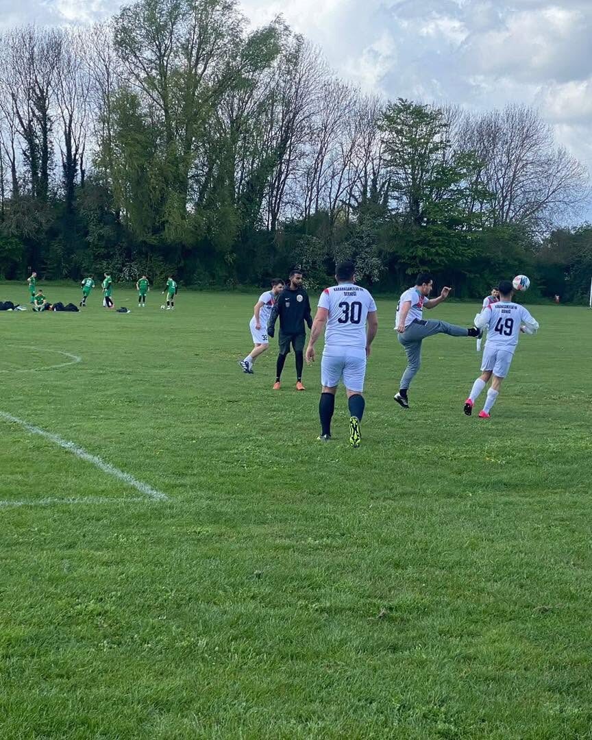 Players in white Karahasanlılar shirts challenging for the ball during a match