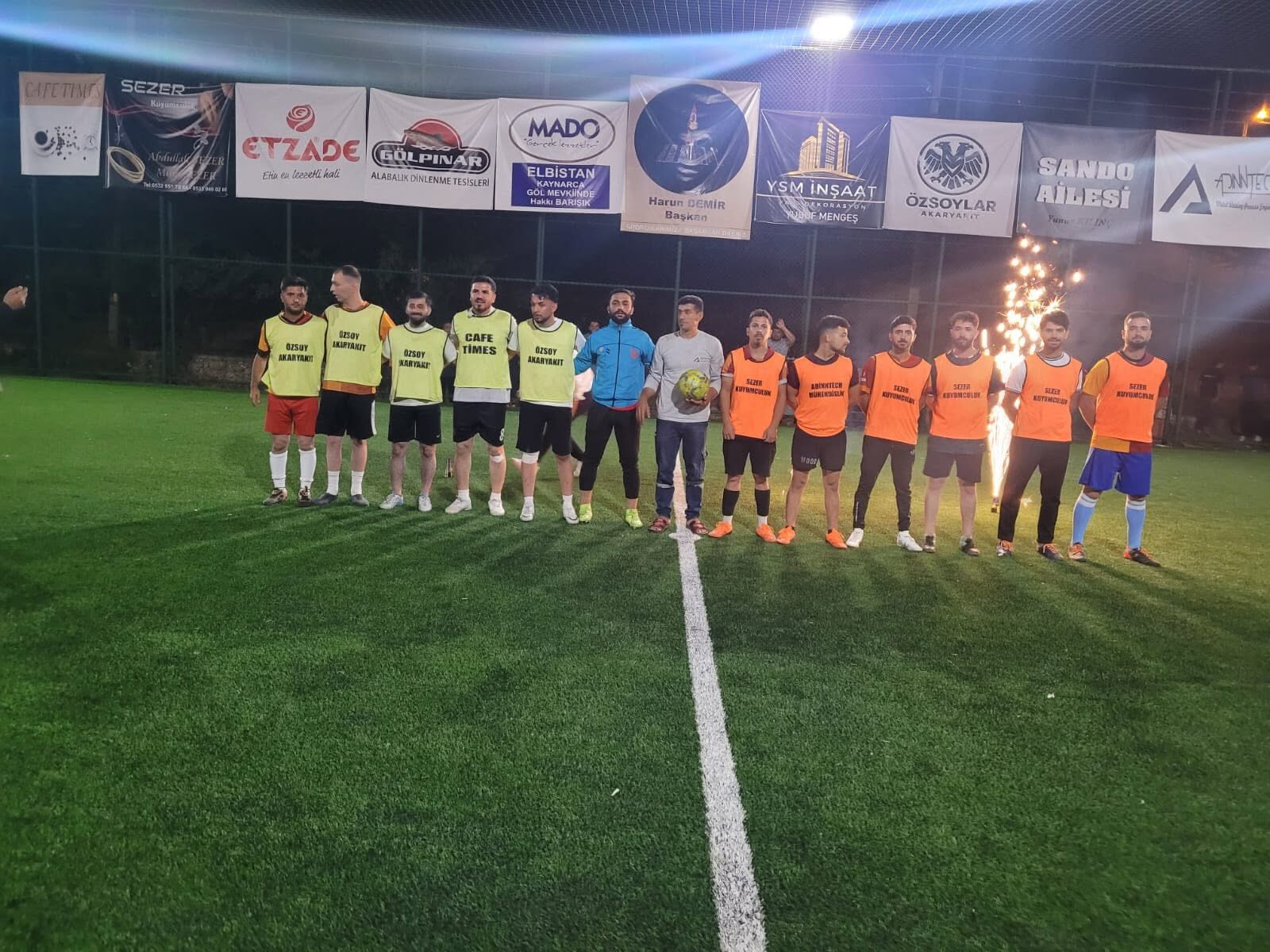 Two teams lined up on the halfway line before kick-off, sponsor banners behind